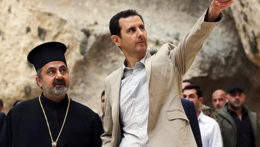 Le président syrien Bashar al-Assad (d) à Maaloula, ancienne ville chrétienne de Syrie, le 20 avril 2014 sur une image de l'agence de presse syrienne (SANA)