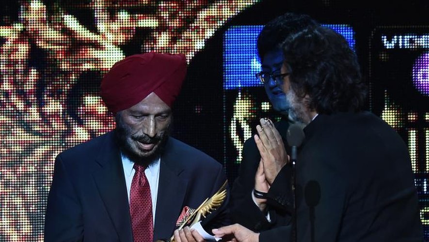 Le réalisateur de Bollywood Rakeysh Omprakash Mehra (d) remet la récompense du meilleur film à Milkha Singh lors de la cérémonie finale du 15e festival international du film indien à Tampa, le 27 avril 2014