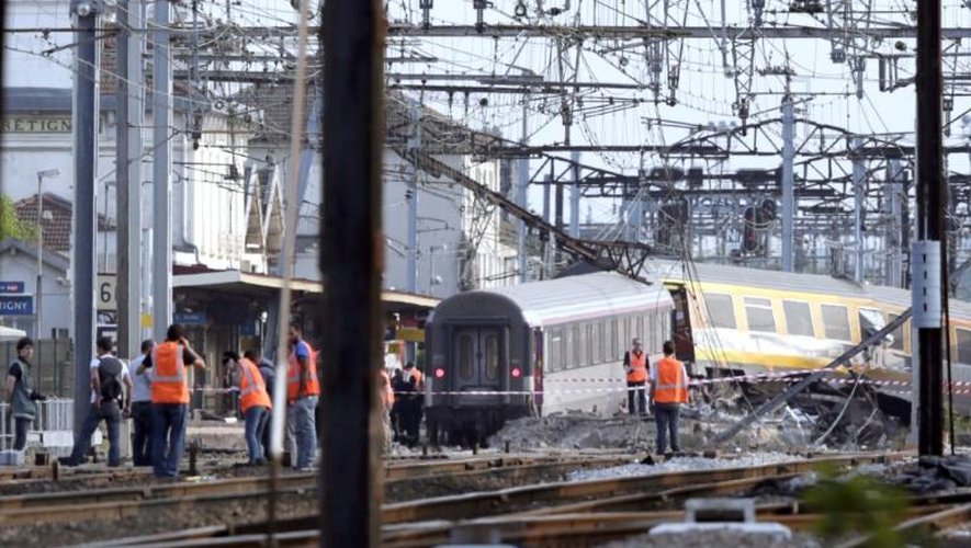 Des secouristes sur les lieux du déraillement meurtrier d'un train à Brétigny-sur-Orge, le 12 juillet 2013