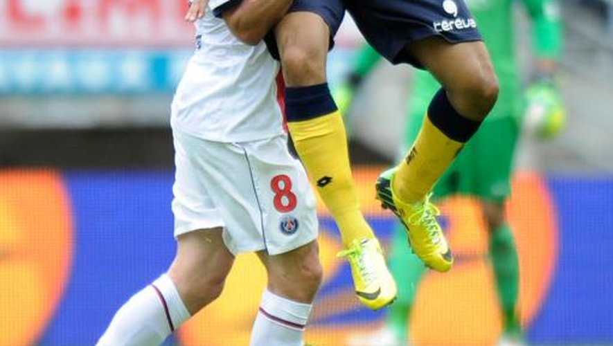 Le milieu italien du PSG Thiago Motta (à gauche) à la lutte avec le Sochalien Jordan Ayew pendant Sochaux-PSG en championnat le 27 avril 2014 à Sochaux