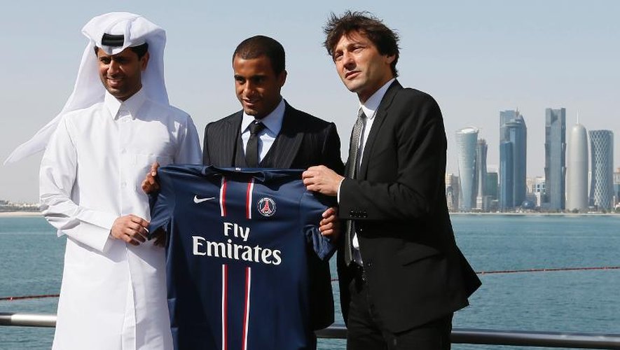 Le milieu du PSG Lucas Moura (c) aux côtés du président de Qatar Sports Investments (QSI), Nasser al-Khelaifi (g) et l'ancien directeur sportif Leonardo, à Doha le 1er janvier 2013