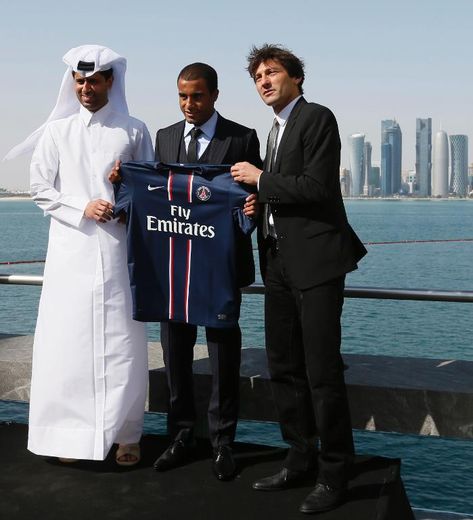 Le milieu du PSG Lucas Moura (c) aux côtés du président de Qatar Sports Investments (QSI), Nasser al-Khelaifi (g) et l'ancien directeur sportif Leonardo, à Doha le 1er janvier 2013
