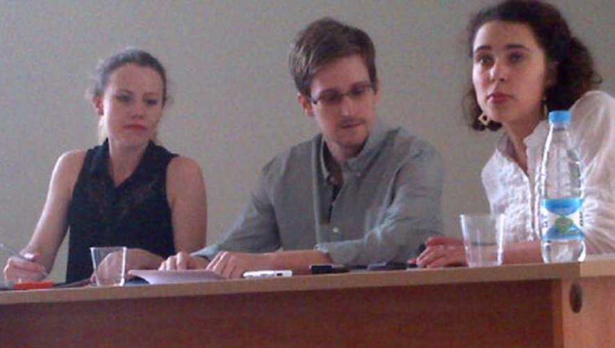 Photo fournie par Human Rights Watch (HRW) de l'ex-consultant américain Edward Snowden (c) en compagnie de Sarah Harrison (g), membre de Wikileaks, le 12 juillet 2013 à l'aéroport de Moscou-Cheremetievo