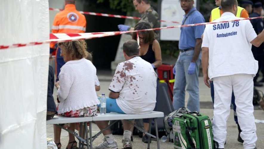 Des secouristes se tiennent aux côtés des blessés dans l'accident de train à Brétigny-sur-Orge (Essonne), près de Paris, le 12 juillet 2013