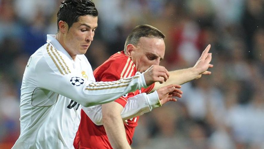 L'attaquant du Real Madrid Christiano Ronaldo (g) aux prises avec celui du Bayern Munich Franck Ribéry lors de la demi-finale aller de la Ligue des champion à Madrid, le 25 avril 2014