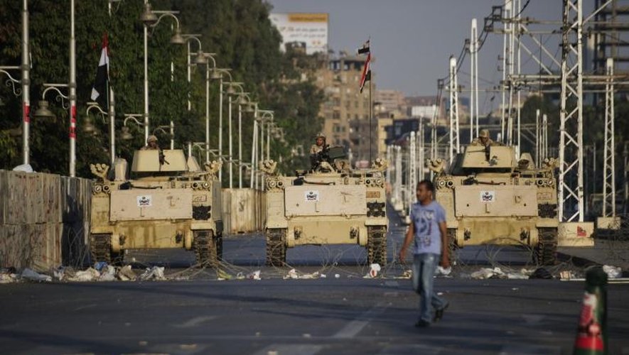 Un homme passe devant des blindés de l'armée égyptienne , le 13 juillet 2013 au Caire