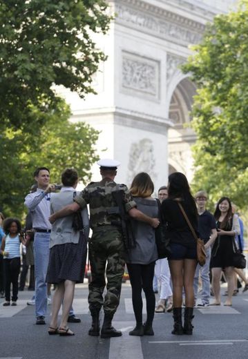 Un soldat français pose avec des touristes sur les  Champs Elysées, le 14 juillet 2013 à Paris