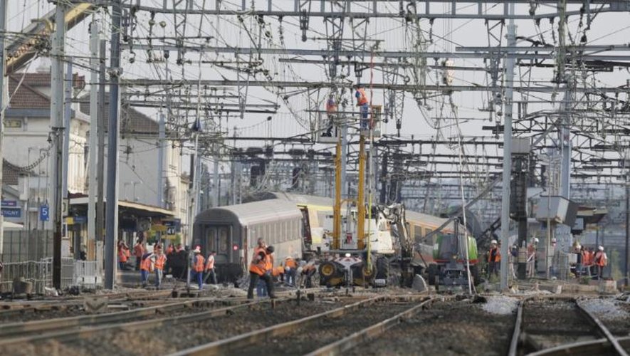 Les secours travaillent en gare de Brétigny-sur-Orge où un train a déraillé, le 13 juillet 2013