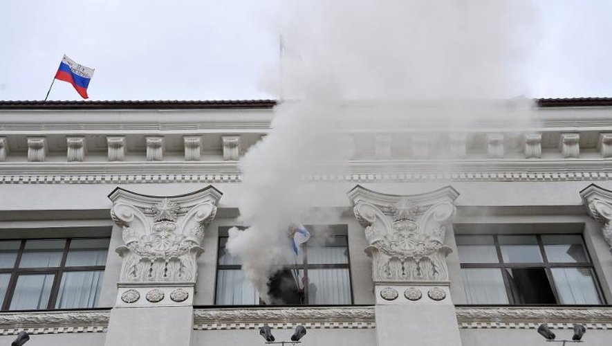 La fumée sort d'une fenêtre de la préfecture de région de Loubansk, prise le 29 avril 2014 par des manifestants pro-russes, qui ont planté le drapeau russe sur le toit
