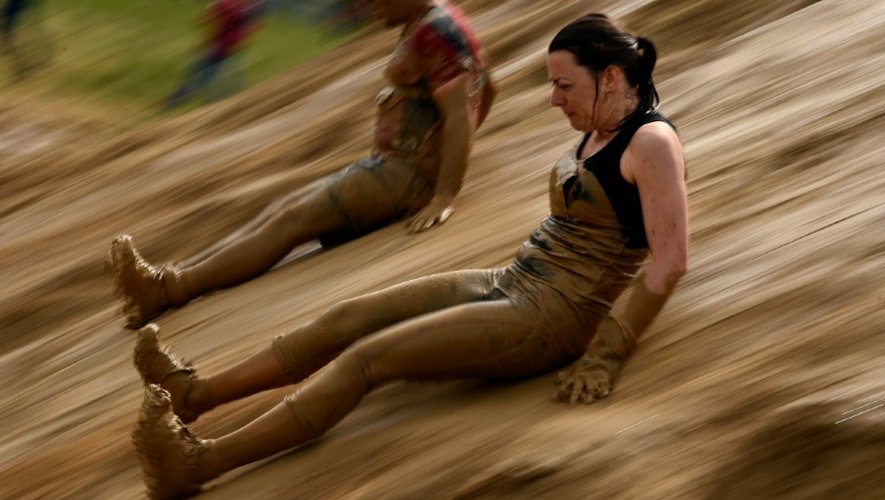 Des participants du "Mud day challenge" glissent dans la boue lors d'une des épreuves de la course d'obstacles, à Beyne, le 7 mai 2016