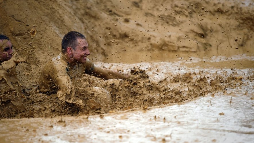 Un participant du "Mud day challenge", patauge dans la boue lors de la course d'obstacles, le 7 mai 2016 à Beyne près de Paris