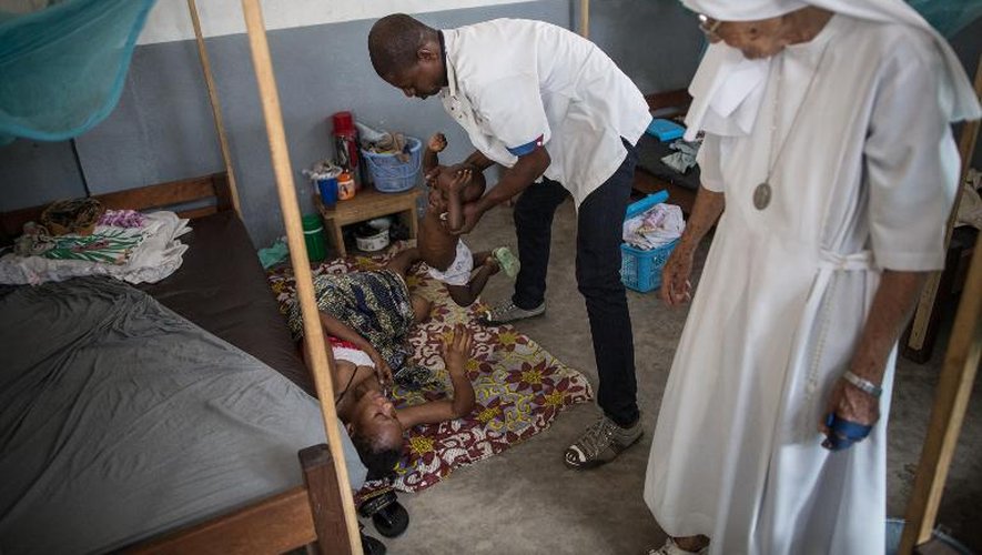 La religieuse Marie Concetta et un assistant aident une mère qui souffre d'une perforation de l'utérus causée par un avortement mal exécuté dans l'hôpital de Zongo, en RDC le 21 juin 2015