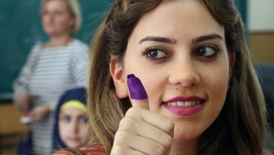 Une Libanaise montre son doigt taché d'encre, après avoir voté aux élections municipales, le 8 mai 2016 à Beyrouth