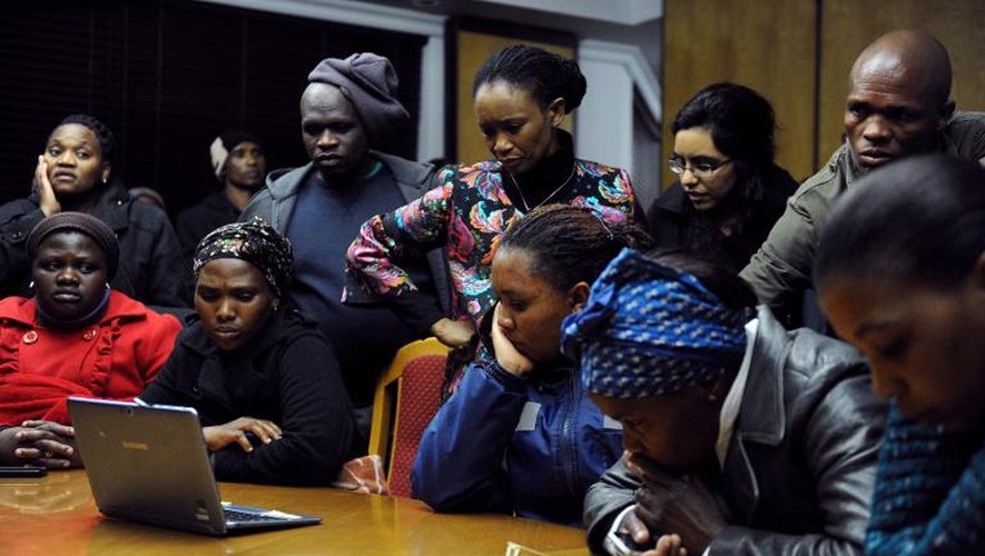 Des proches des victimes de la tuerie de 2012 à la mine de Marikana écoutent l'annonce par le président Jacob Zuma des conclusions de la commission d'enquête, le 25 juin 2015 à Marikana, près de Rustenburg, en Afrique du Sud