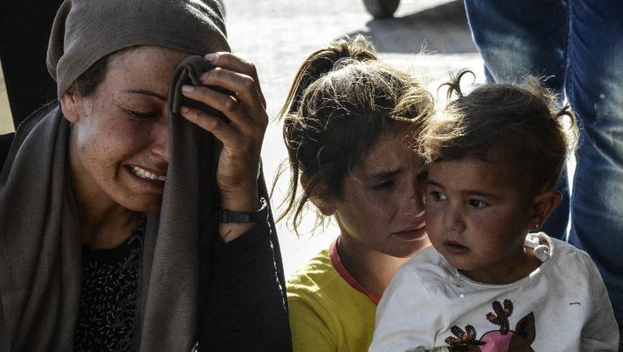 Des familles pleurent à l'hôpital de Suruc, dans la province turque de Sanliurfa le 25 juin 2015 après une attaque suicide à Kobane, de l'autre côté de la frontière, tuant 12 civils