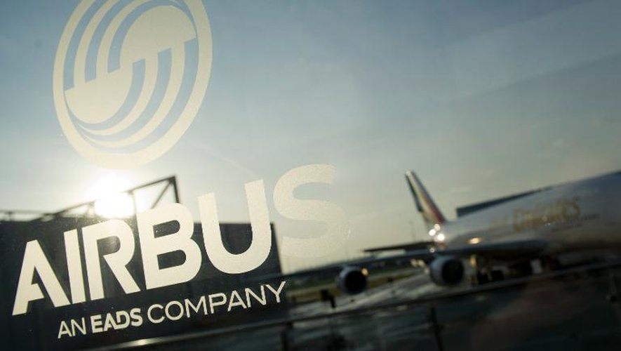 Un Airbus A380 derrière une vitre sur laquelle se trouve le logo du groupe aéronautique, à l'aéroport d'Hambourg, en Allemagne, en 2012