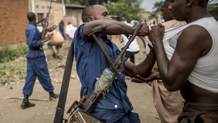 Un policier arrête un homme après une bagarre avec des habitants en colère contre une opération de fouille dans le quartier de Cibitoke, à Bujumbura, au Burundi