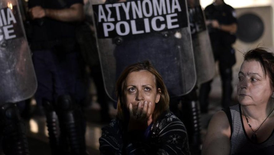 Des manifestantes devant un cordon de police protégeant le Parlement à Athènes, le 17 juillet 2013