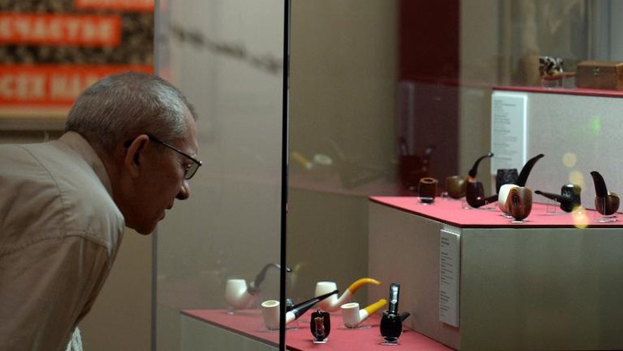 Un visiteur de l'exposition "Le mythe du chef bien-aimé" regarde une collection de pipes de Joseph Staline, musée d'Histoire de Moscou, le 2 avril 2014