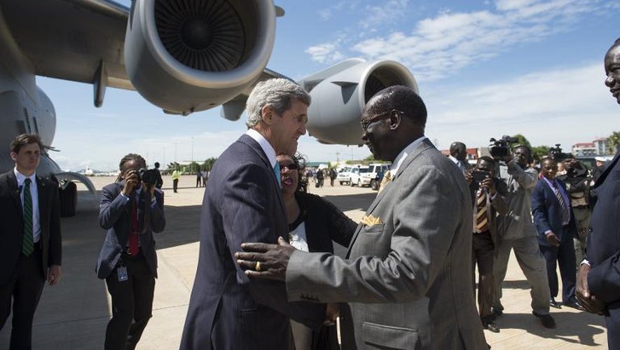 Le ministre sud-soudanais Barnaba Marial Benjamin (d) accueille le secrétaire d'Etat américain John Kerry (g) à son arrivée l'aéroport international de Juba, le 2 mai 2014