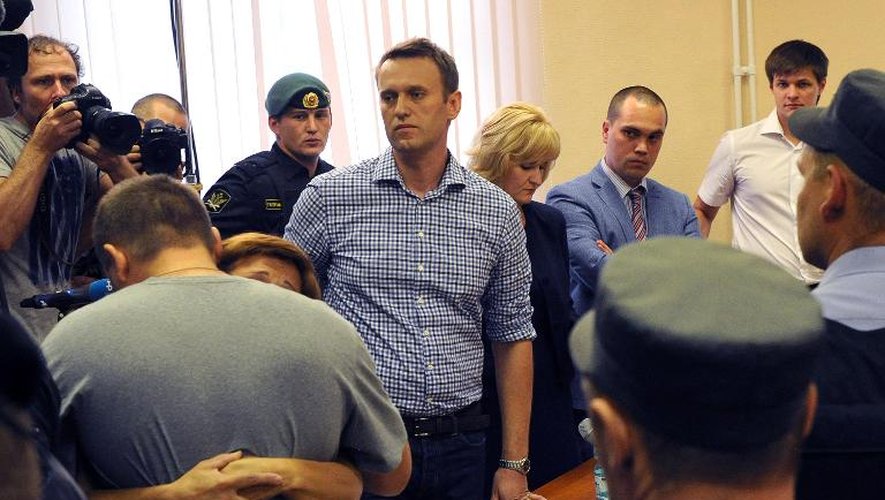 L'opposant Alexeï Navalny se tient debout à côté de son coaccusé qui serre dans ses bras un proche après leur condamnation, le 18 juillet 2013 à Kirov
