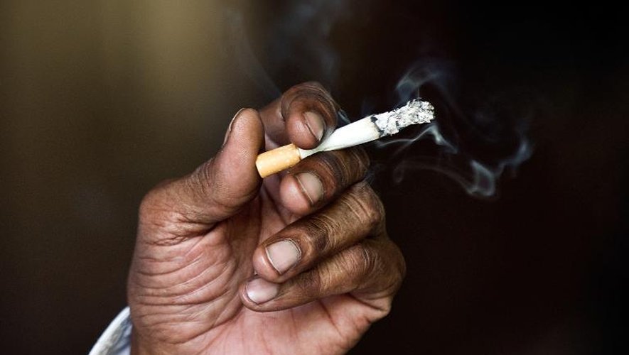 Un homme fume une cigarette à New Delhi le 31 mai 2013