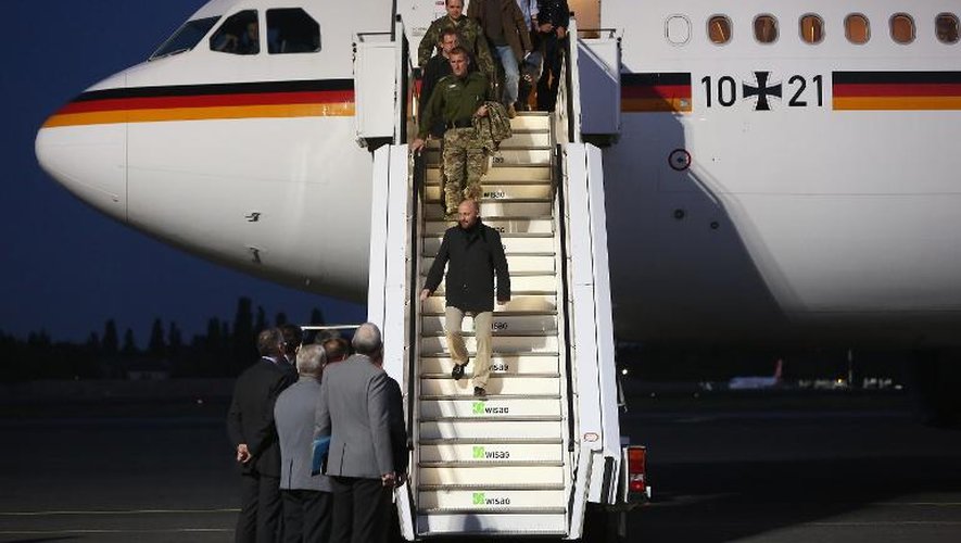 Axel Schneider, colonel dans la Bundeswehr (au centre), et d'autres membres de l'équipe d'observateurs de l'OSCE qui étaient retenus en otage en Ukraine arrivent à Berlin après leur libération, le 3 mai 2014