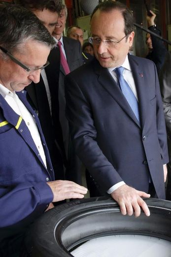 Le président français François Hollande discute avec un salarié de l'usine Michelin à Cebazat, le 18 avril 2014