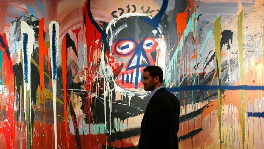 Loic Gouzer de Christie's passe devant la toile "sans titre" de Bsquiat le 29 avril 2016 lors d'une présentation à la presse à New York