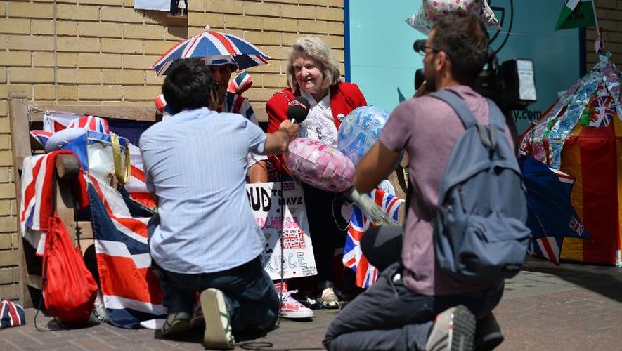Une équipe de journalistes interviewent une Britannique qui patiente devant l'hôpital St Mary à Londres, le 18 juillet 2013
