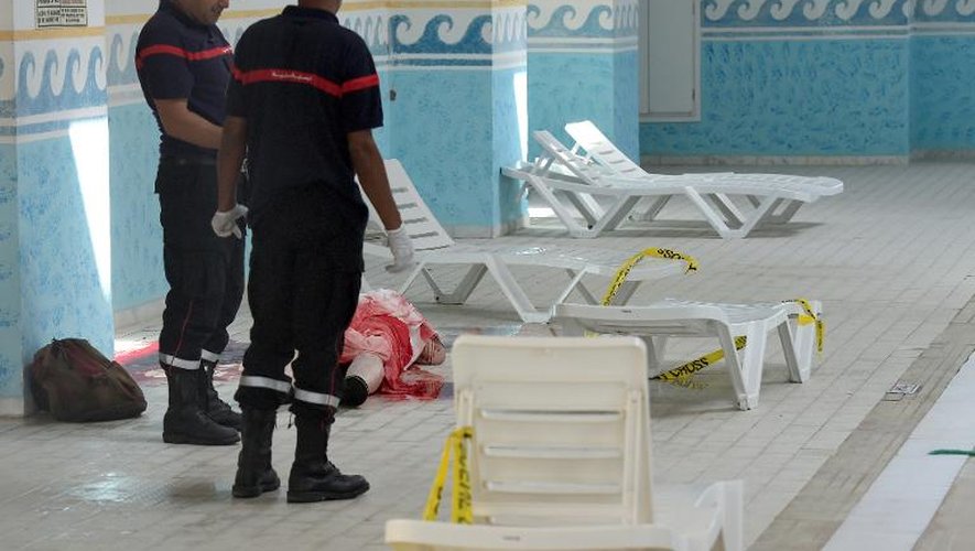 Des secourists tunisiens près du corps d'un touriste tué lors de l'attaque d'un hôtel de la station balnéaire de Sousse, le 2- juin 2015