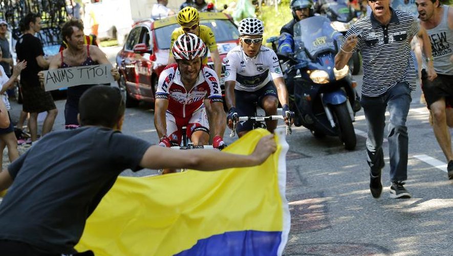 Un supporteur, avec le drapeau colombien, encourage Nairo Quintana (d), lors de la 20e étape du Tour de France