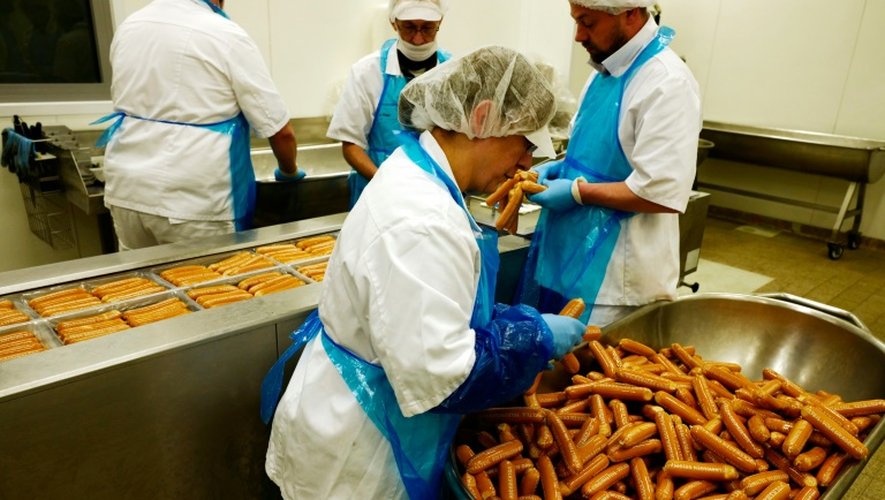 Des employés du constructeur automobile allemand Volkswagen emballent des saucisses au curry produites au siège de l'entreprise à Wolfsburg en Allemagne le 21 avril 2016