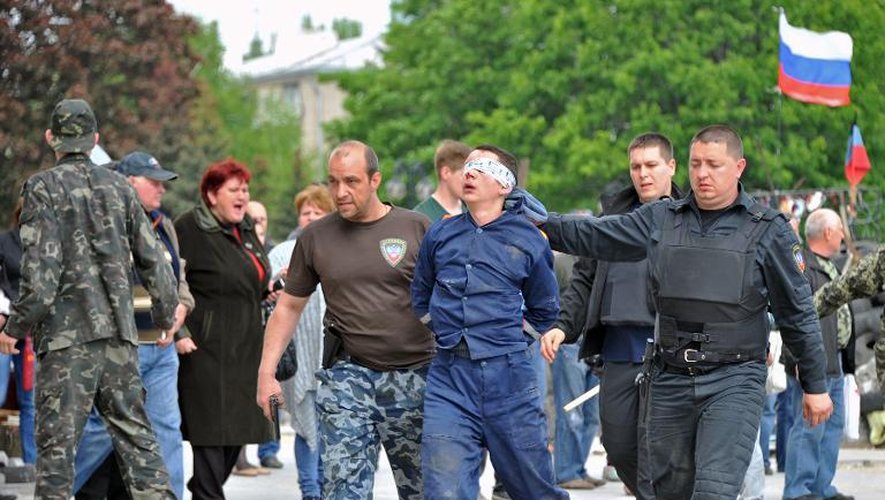 Un homme les yeux bandés est emmené par des activistes pro-russes le 5 mai 2014 à Donetsk