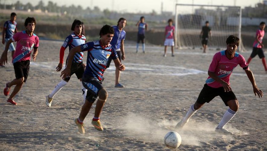 De jeunes Irakiens jouent au foot, près de Bagdad le 4 juillet 2013