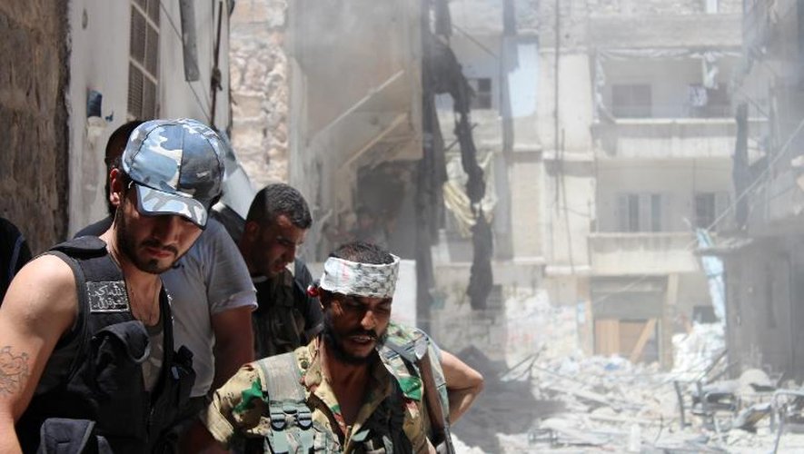 Des rebelles syriens se replient après avoir détruit un immeuble d'Alep, le 10 juillet 2013