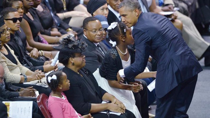 Le président Barack Obama  salue Malana (g) et Eliana (d), les filles du pasteur Clementa Pinckney qui encadrent leur mère Jennifer Pinckney, le 26 juin 2015 à Charleston