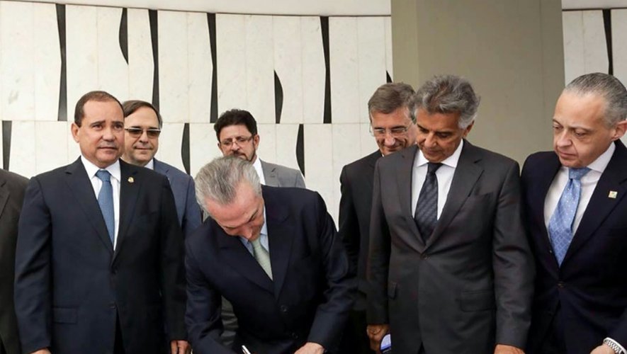 Le vice-président Michel Temer signe les documents lui permettant d'assurer la présidence du Brésil par intérim, le 12 mai 2016 à Brasilia