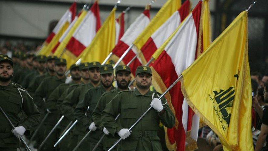 Des combattants du Hezbollah, brandissant le drapeau libanais et celui du mouvement chiite, dans la banlieue de Beyrouth, le 11 novembre 2009