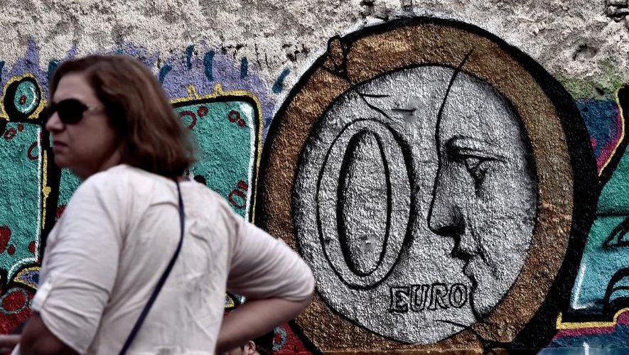 Une personne passe devant un graffiti dans les rues d'Athènes,le 27 juin 2015
