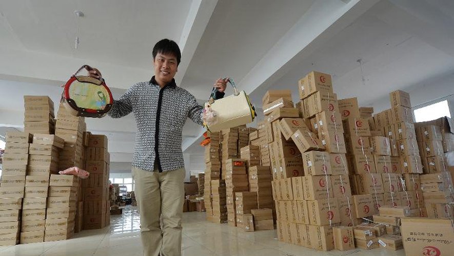 Huang Jianqiao montre les sacs à main qu'il confectionne, dans son entrepôt de Baigou le 24 avril 2014