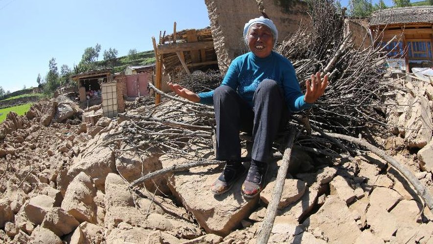 Une femme éclate en sanglots le 22 juillet 2013 sur les ruines de sa maison, détruite par un séisme qui a eu lieu dans la province chinoise du Gansu