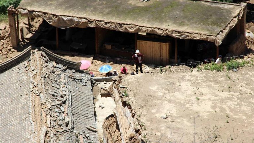 Des habitants de la région de Dingxi au milieu des débris de leur maison, le 22 juillet 2013, après un séisme qui a touché la province chinoise du Gansu