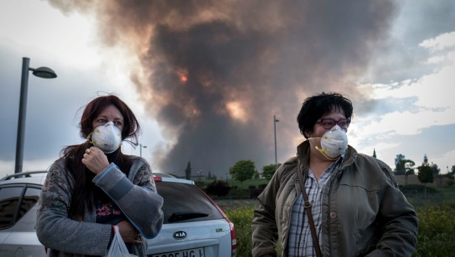 Des riverains de Seseña attendent d'être évacués alors qu'un nuage de fumée toxique se dirige vers la ville espagnole, après un incendie dans une décharge sauvage de pneus le 13 mai 2016