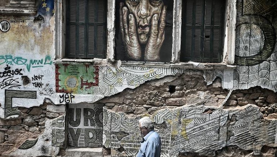 Une personne passe devant un graffiti dans les rues d'Athènes, le 28 juin 2015