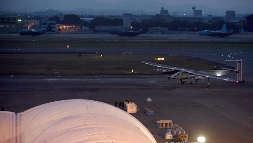 Du personnel au sol s'affaire autour du hangar de l'avion Solar Impulse 2, le 24 juin 2015 à l'aéroport de Nagoya, dans le centre du Japon