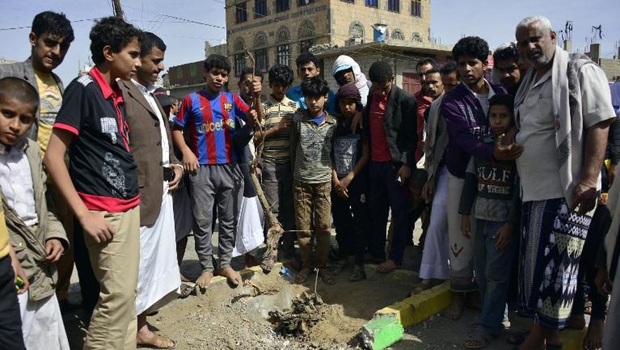 Des Yéménites se rassemblent sur le lieu d'une explosion près d'un point de contrôle à Sanaa menant à une rue abritant des ambassades occidentales, le 9 mai 2014