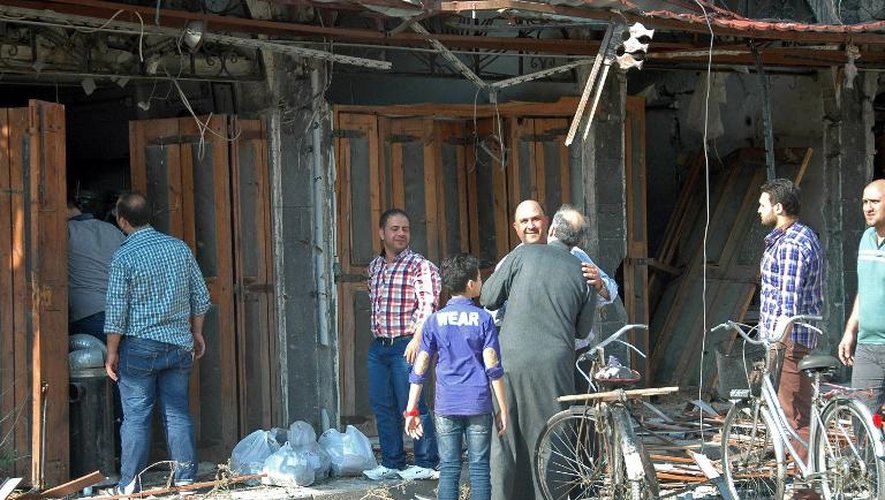 Photo diffusée par l'Agence de presse syrienne Sana montrant des Syriens retournant dans la quartier chrétien de Hamidiyed de la vieille ville de Homs le 9 mai 2014, après le départ des derniers rebelles suite à un accord avec les troupes g