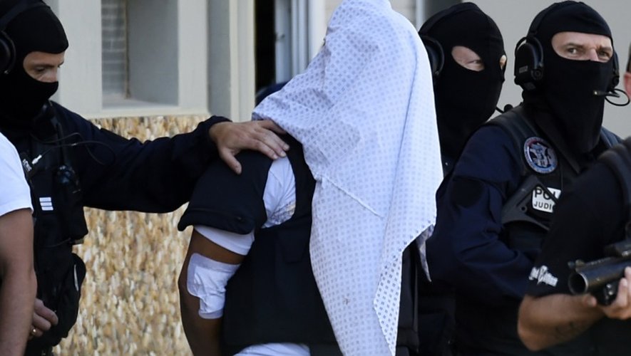 Yassin Salhi entre des policiers lors de la perquisition à son domicile le 28 juin 2015 à Saint-Priest