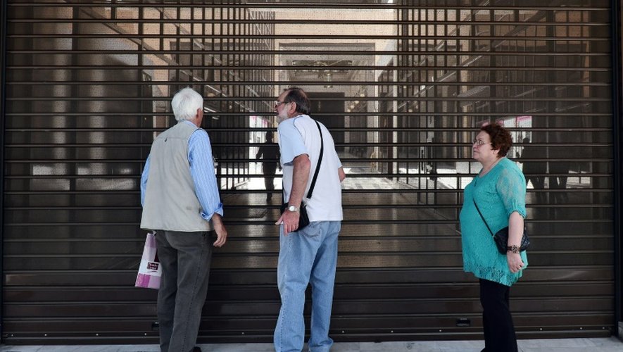 Des retraités devant les rideaux de la banque Alpha Bank à Athènes
